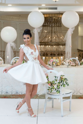 bride showing off her pretty white dress in front of the head table and a large chandelier. all in a days work